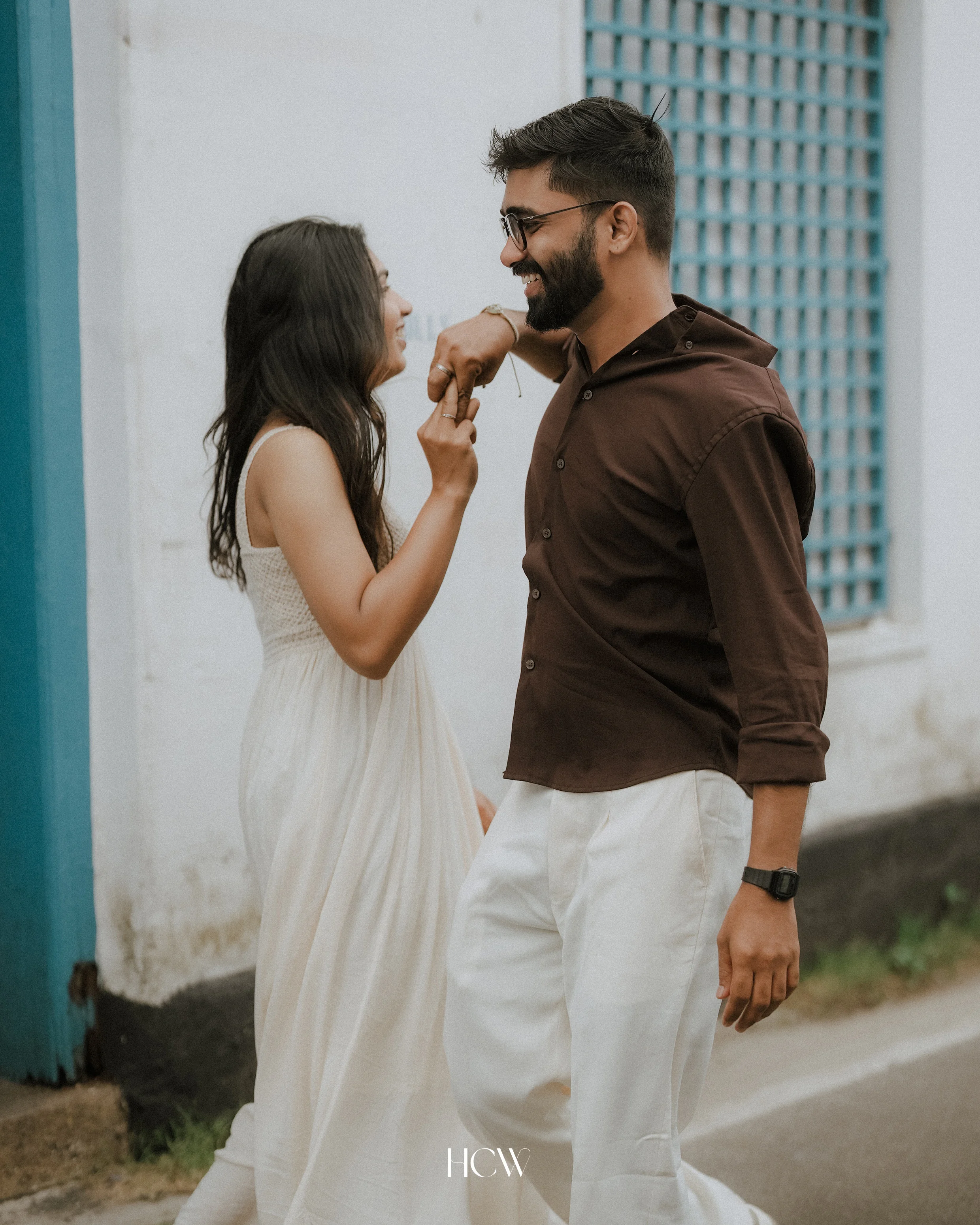 Couple laughing beside a blue doorway
