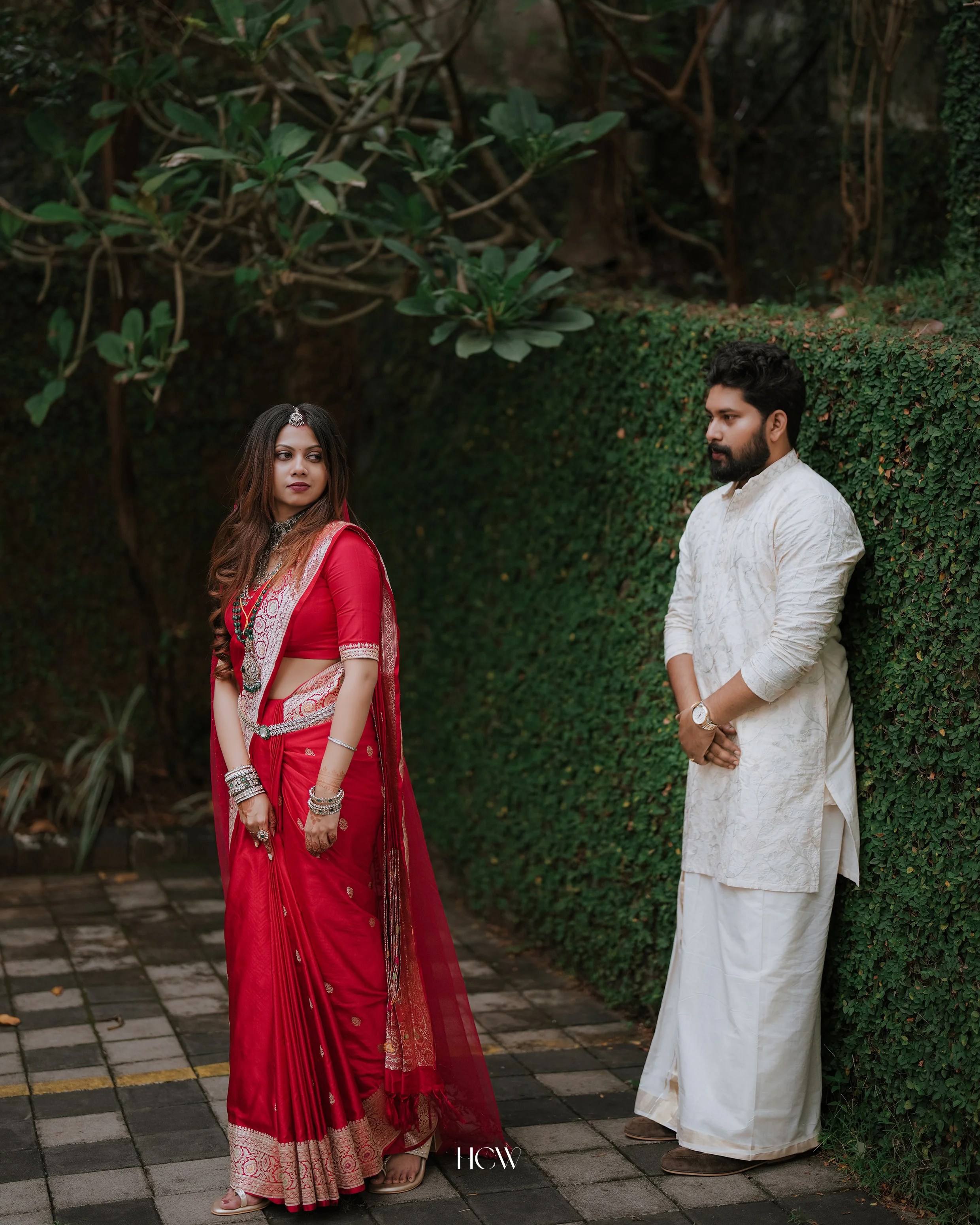 Couple in traditional wedding attire in a garden