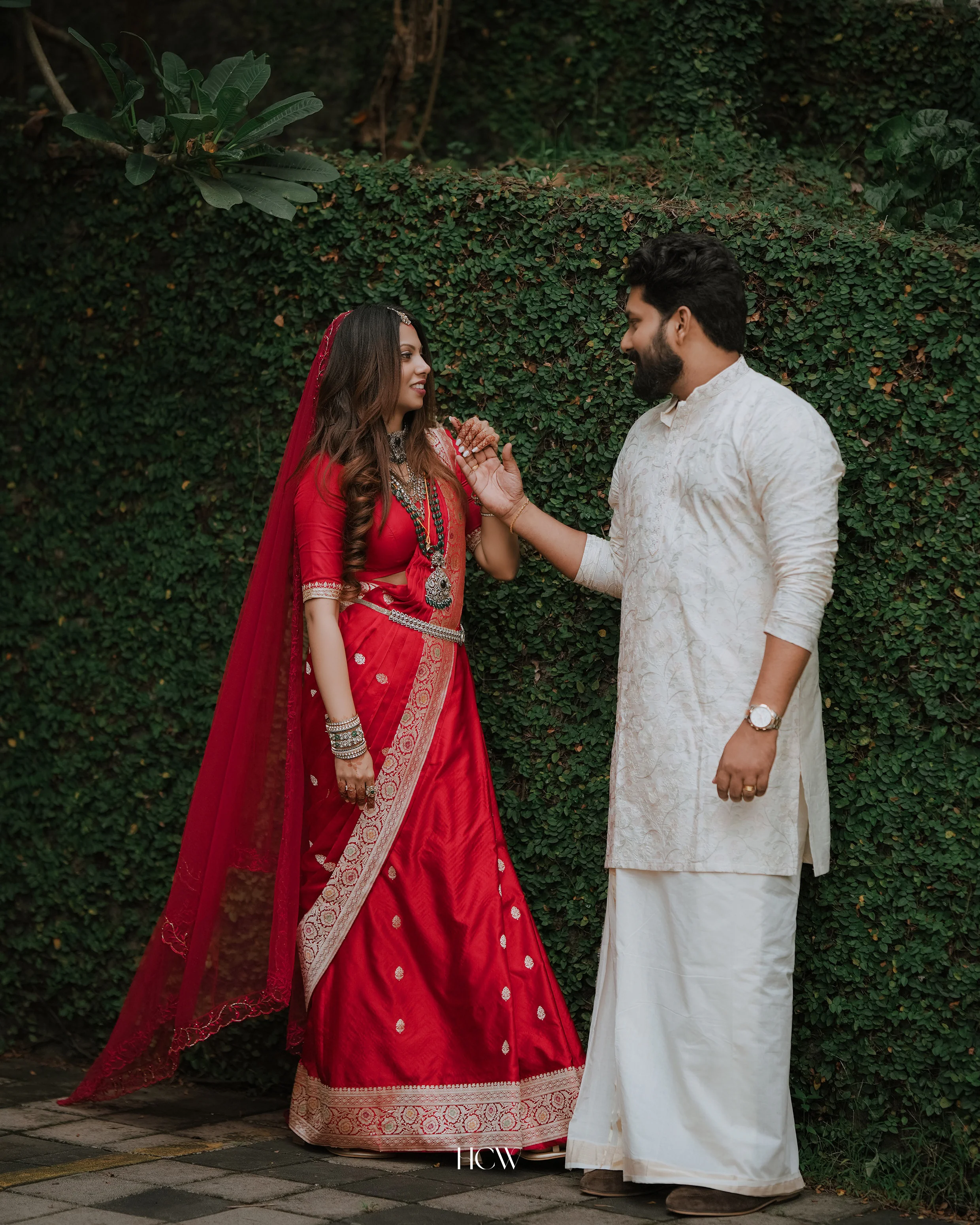 Couple sharing a playful moment by a garden wall
